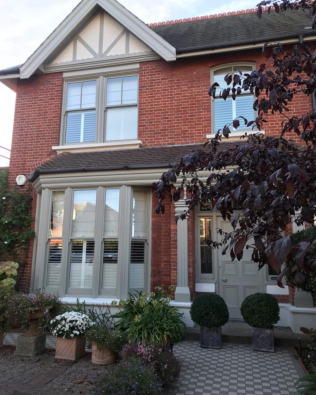 Red brick Edwardian house with freshly painted bay windows and woodwork